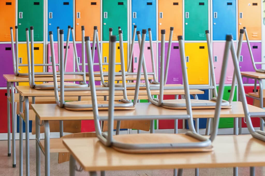 stacked chairs on desks in a classroom